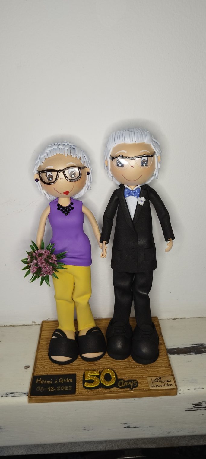 Pareja de figuras, una mujer con ramo de flores y un hombre de traje, 50 años de casodos.