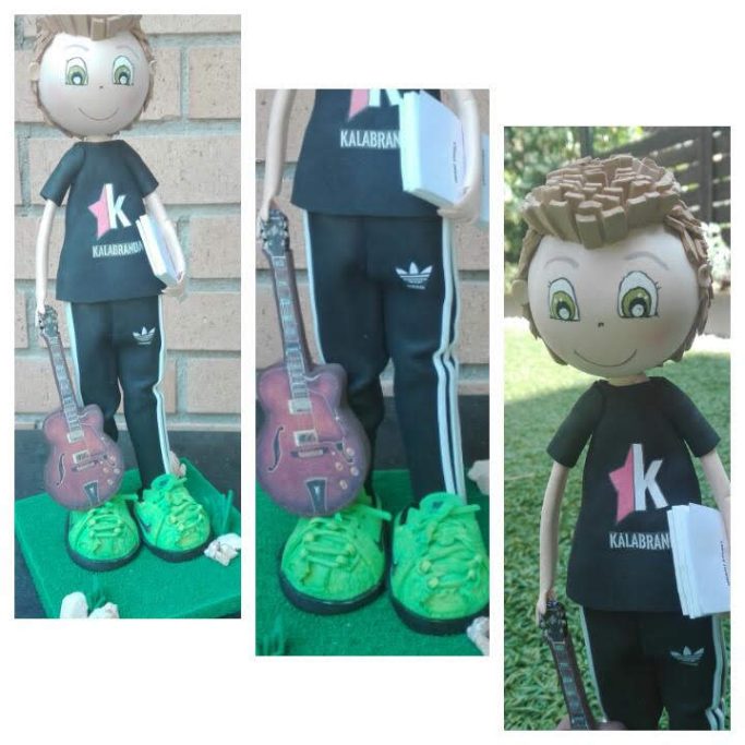 Muñeco con guitarra, vestido con camiseta negra y pantalones deportivos.