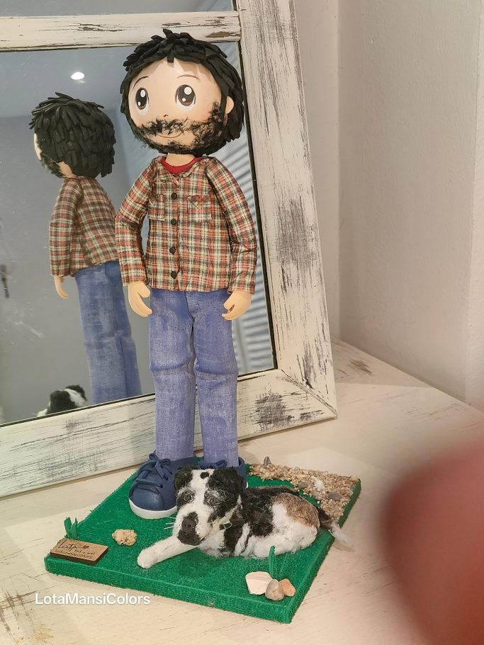 Figura de un hombre con barba y perro en una base, reflejados en un espejo.