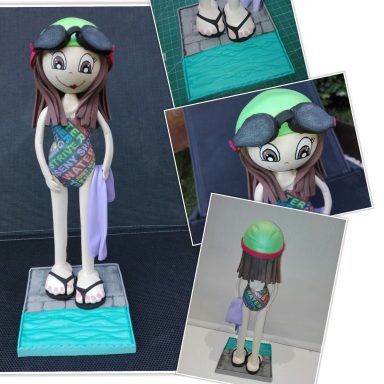 Fofucha personalizada con bañador de letras, gorro verde, gafas y una toalla en la mano a punto de entrar en la piscina