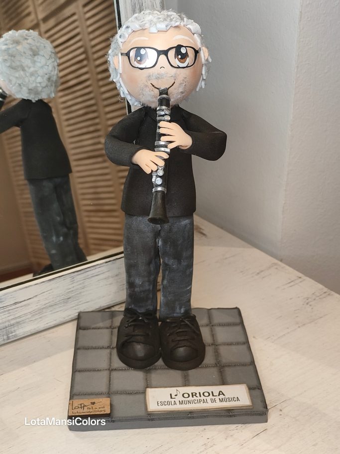 Muñeco músico  vestido de negro con gafas tocando un clarinete.
