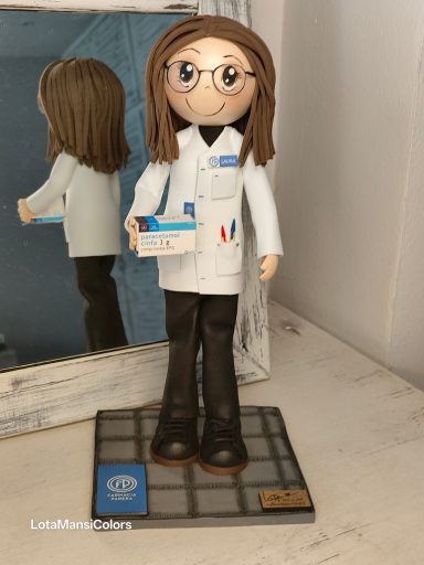 Fofucha personalizada farmacéutica  vestida con bata blanca y gafas, sosteniendo una caja de paracetamol.