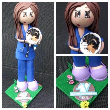 Fofucha veterinaria con uniforme azul sosteniendo un perro con campana y la patita vendada.