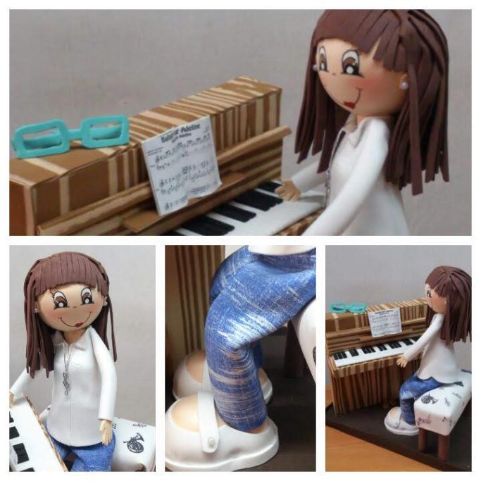 Muñeca de cerámica tocando un piano, con gafas sobre el instrumento y pantalones de mezclilla.