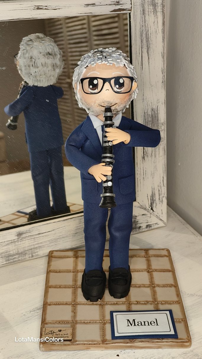 Muñeco con traje y corbata azul tocando el clarinete.
