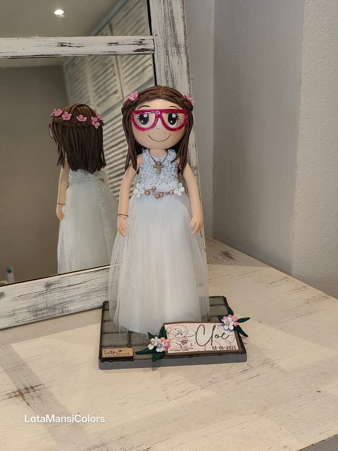 Muñeca con vestido blanco de tul y gafas rosas.