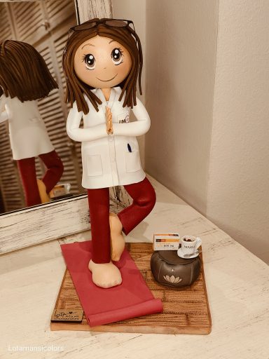 Fofucha personalizada farmacéutica Fofucha farmacéutica haciendo yoga en postura de meditación, junto a productos, un café,una caja de paracetamol.