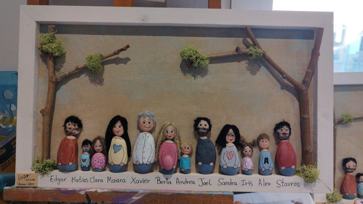 Figuras de personas pintadas en un fondo natural con árboles y elementos decorativos.