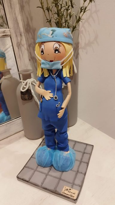 Fofucha  personalizada cirujana  embarazada con uniforme azul, gorro y mascarilla, con sus patucos.