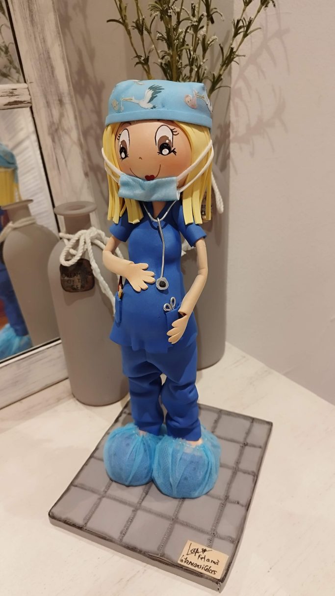 Fofucha cirujana  embarazada con uniforme azul, gorro y mascarilla, con sus patucos.