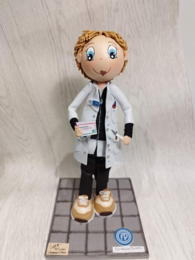 Muñeco de un doctor con bata blanca, cabello rizado y zapatos claros.
